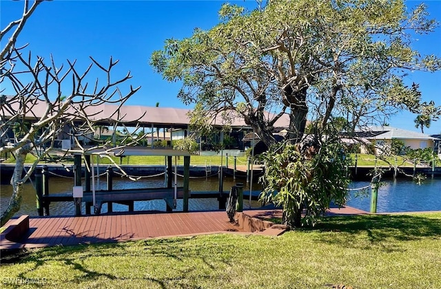 view of dock with a water view, boat lift, and a lawn