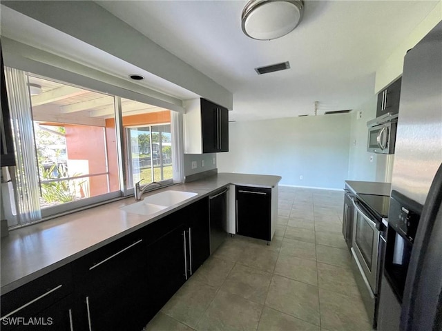 kitchen featuring stainless steel appliances, a sink, visible vents, and dark cabinets