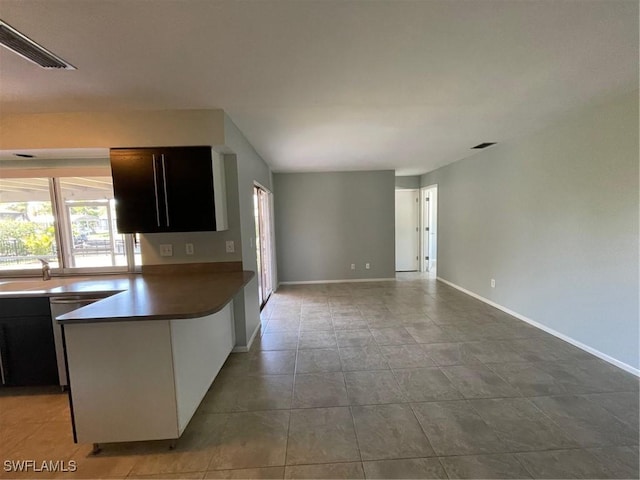 kitchen with baseboards, visible vents, open floor plan, and dishwasher