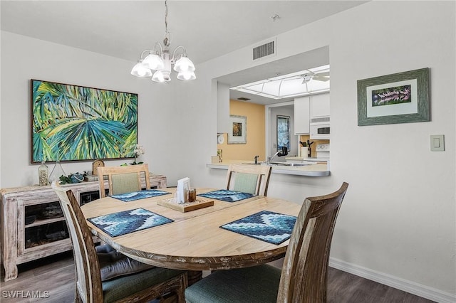 dining room featuring a notable chandelier and dark wood-type flooring