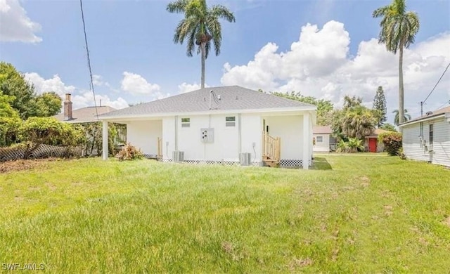 rear view of property featuring a yard and central air condition unit