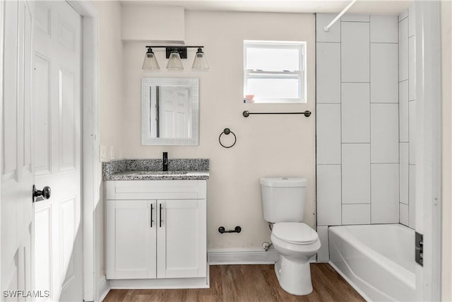 full bathroom featuring hardwood / wood-style flooring, toilet, vanity, and tiled shower / bath combo