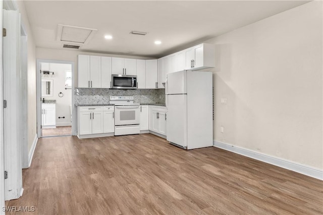 kitchen featuring white appliances, white cabinetry, light hardwood / wood-style flooring, and decorative backsplash