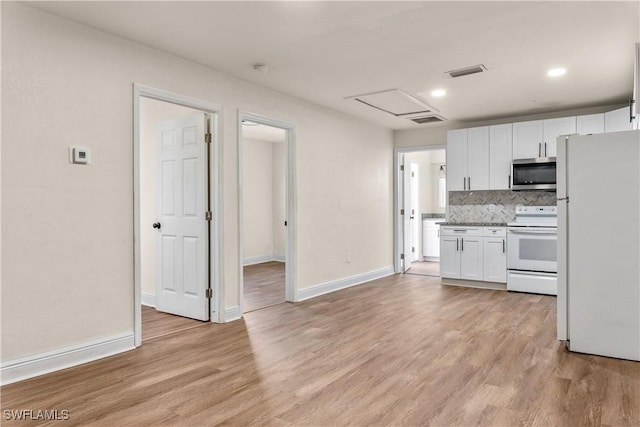 kitchen featuring white appliances, light hardwood / wood-style floors, white cabinets, and tasteful backsplash