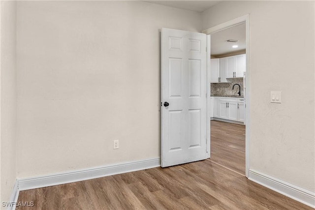 unfurnished room with light wood-type flooring and sink