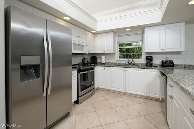 704 107th Ave N, Naples, FL 34108 - kitchen featuring appliances with stainless steel finishes, a sink, tasteful backsplash, white cabinets, and recessed lighting