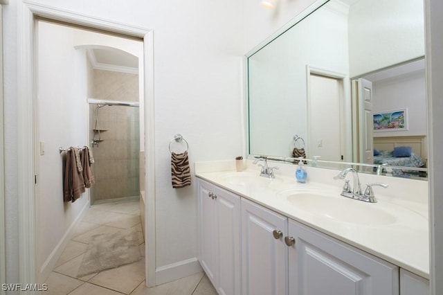 704 107th Ave N, Naples, FL 34108 - ensuite bathroom with tile patterned floors, double vanity, a tile shower, crown molding, and baseboards