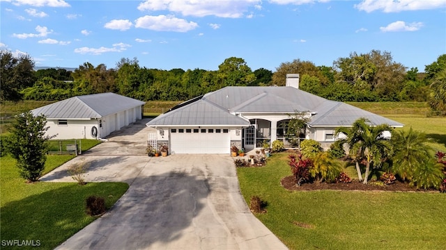 view of front facade with driveway, a garage, a chimney, and a front yard