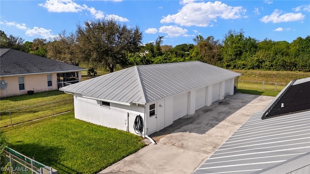 exterior space featuring metal roof, a standing seam roof, fence, a yard, and stucco siding