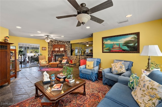 living room with stone tile flooring, a fireplace, visible vents, and recessed lighting