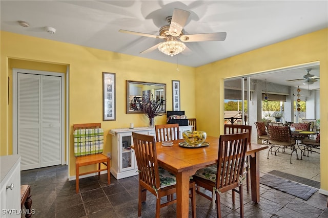 dining room with stone finish floor, ceiling fan, and baseboards