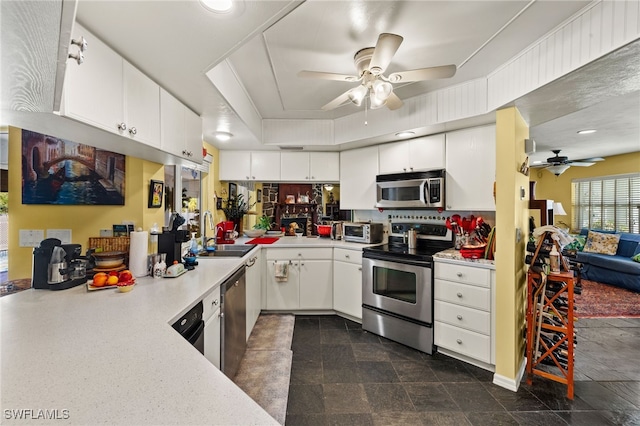 kitchen featuring stainless steel appliances, a sink, light countertops, and white cabinets