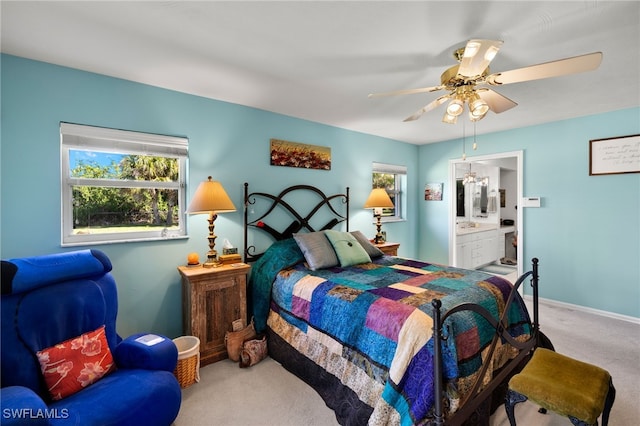 bedroom with carpet floors, ensuite bath, baseboards, and a ceiling fan