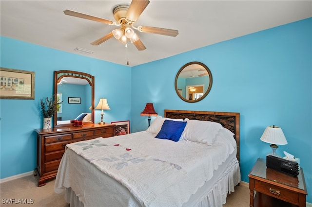 bedroom featuring baseboards, visible vents, a ceiling fan, and light colored carpet