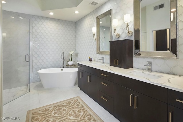 bathroom featuring vanity and independent shower and bath