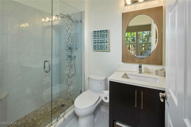 bathroom featuring vanity, toilet, and a shower with door