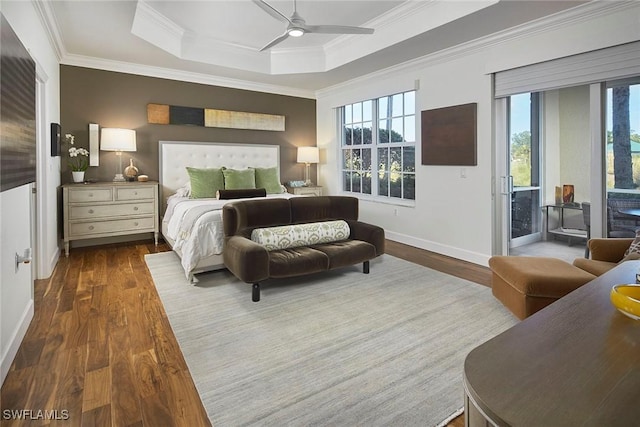 bedroom featuring dark hardwood / wood-style flooring, multiple windows, access to outside, and a raised ceiling