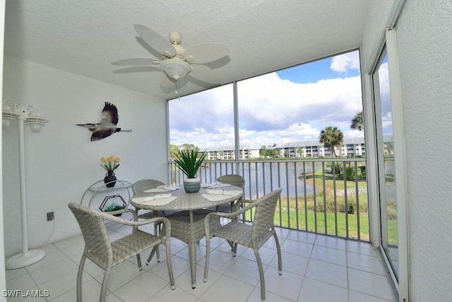 sunroom / solarium with a water view and ceiling fan