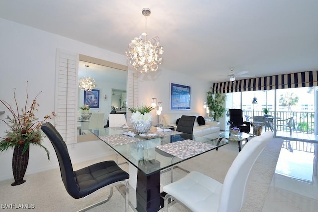 carpeted dining space featuring ceiling fan with notable chandelier