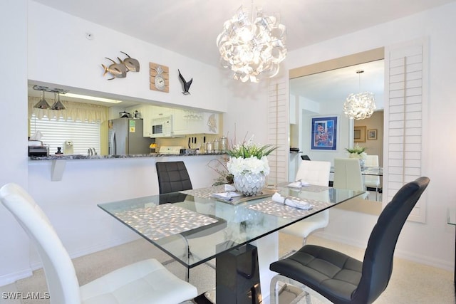 dining area featuring light colored carpet and a chandelier