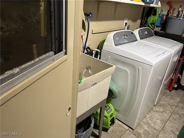 laundry area featuring washing machine and clothes dryer and light tile patterned flooring