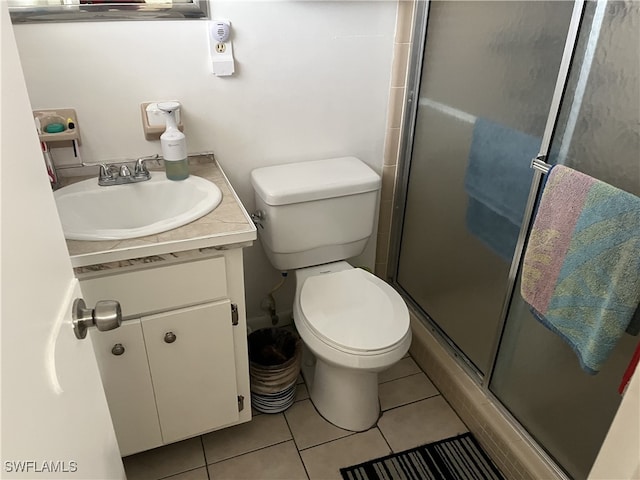 bathroom featuring vanity, a shower with shower door, tile patterned floors, and toilet