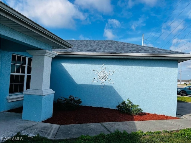 view of home's exterior with a shingled roof and stucco siding