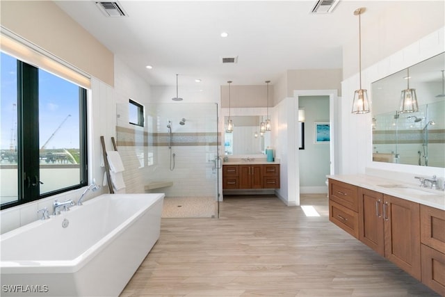 bathroom featuring vanity, shower with separate bathtub, and hardwood / wood-style floors