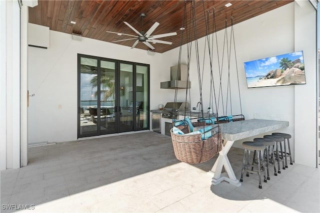 view of patio with area for grilling, ceiling fan, and a bar