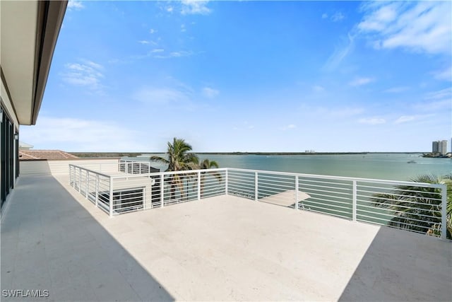 view of patio / terrace with a balcony and a water view