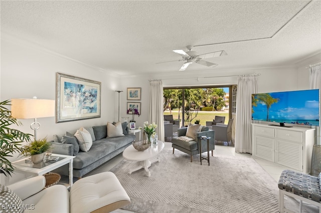 living room with light tile patterned floors, ceiling fan, ornamental molding, and a textured ceiling