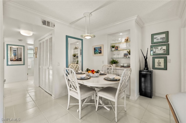 dining space featuring crown molding, light tile patterned floors, visible vents, a textured ceiling, and baseboards