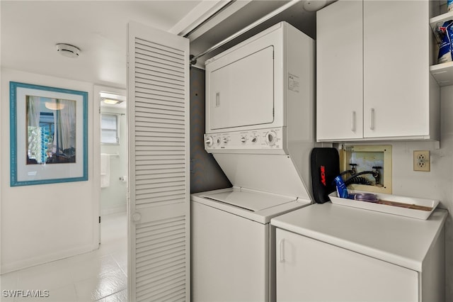 clothes washing area featuring laundry area and stacked washing maching and dryer