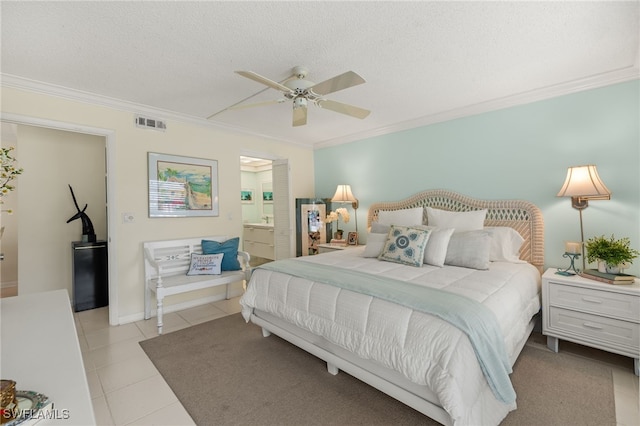 bedroom featuring light tile patterned floors, visible vents, connected bathroom, a textured ceiling, and crown molding