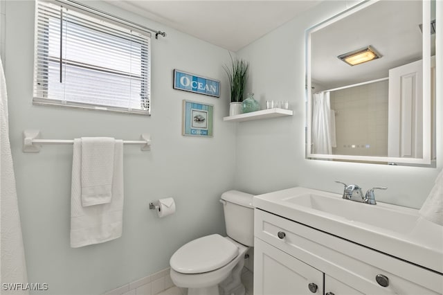 bathroom with curtained shower, vanity, and toilet