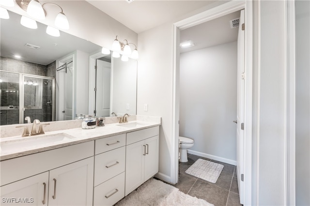 full bathroom with double vanity, a stall shower, a sink, and toilet