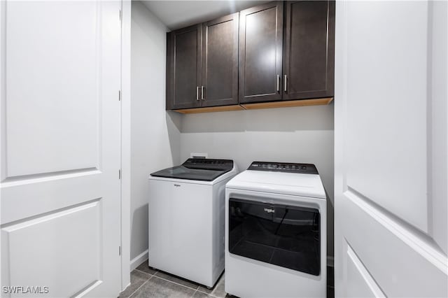 clothes washing area featuring light tile patterned floors, cabinet space, and separate washer and dryer