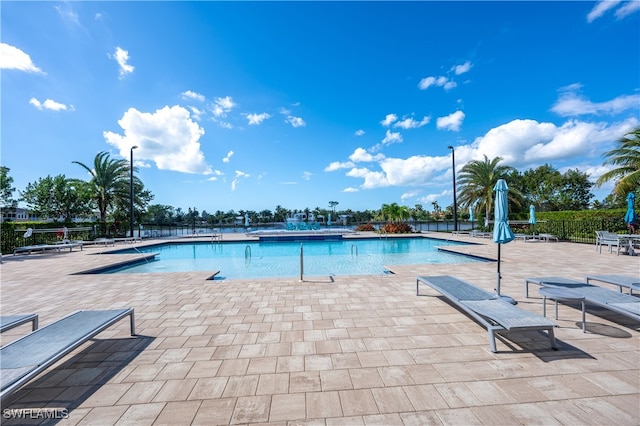 community pool with fence and a patio