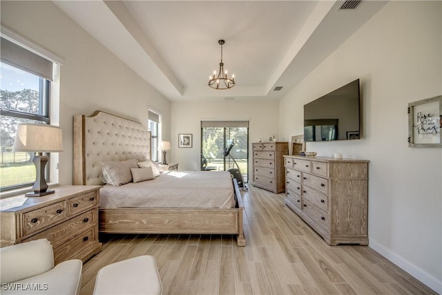 bedroom with a notable chandelier and a tray ceiling