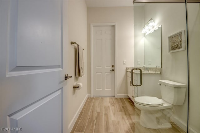 bathroom featuring wood-type flooring and toilet