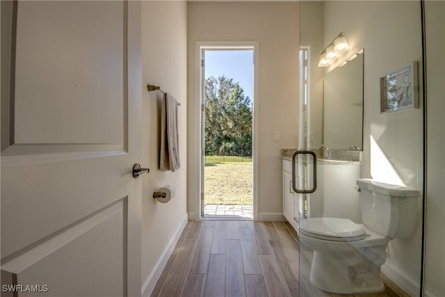 bathroom with hardwood / wood-style flooring, walk in shower, and toilet