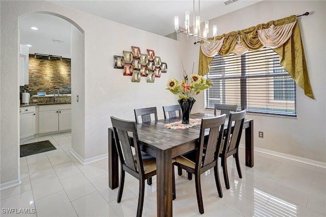 tiled dining area with sink and a notable chandelier