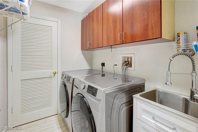 washroom featuring cabinets, washer and dryer, and sink