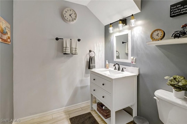 bathroom with vanity, toilet, and vaulted ceiling