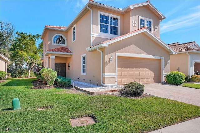 mediterranean / spanish house with a garage and a front lawn