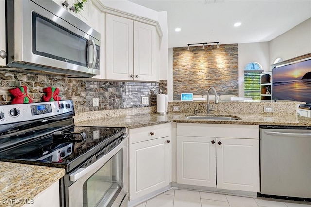 kitchen featuring white cabinetry, sink, light stone counters, and stainless steel appliances