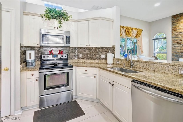 kitchen with backsplash, stainless steel appliances, sink, and white cabinets