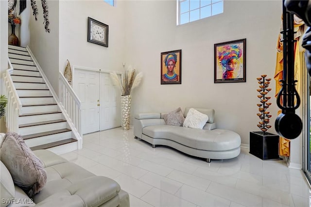 living room with a towering ceiling and light tile patterned floors