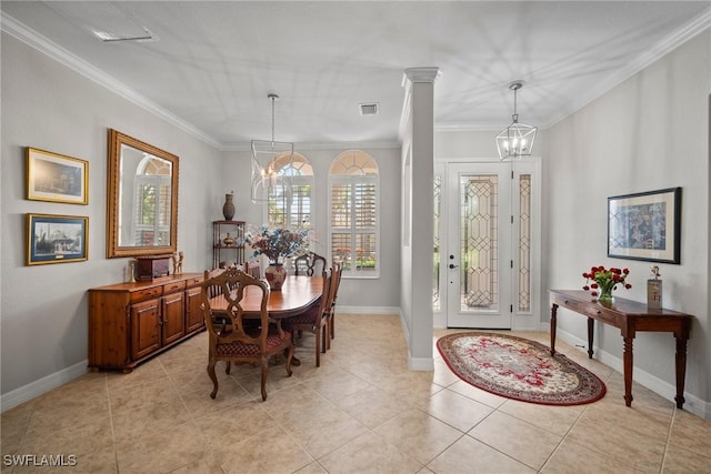 tiled dining area featuring crown molding, a notable chandelier, and ornate columns