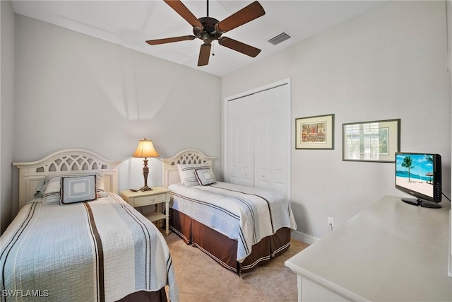 bedroom featuring light tile patterned flooring, ceiling fan, and a closet